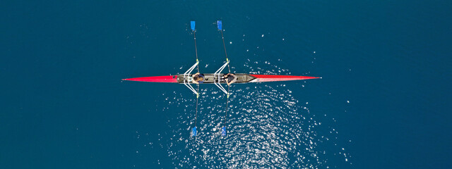 Aerial drone top ultra wide panoramic view of sport canoe rowing synchronous female athletes...