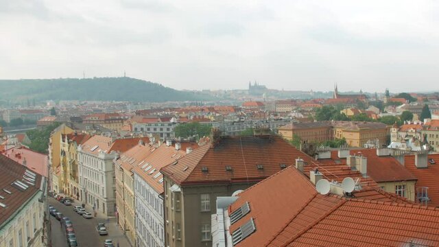 young blonde woman is taking photos of panorama of Prague city by modern smartphone in daytime