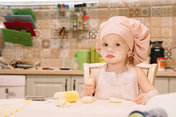 Little girl cooks at home in the kitchen