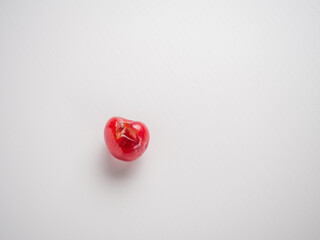 Spoiled fruits of red cherries on a white background
