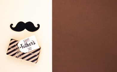 Happy fathers Day gift tag with shiny confetti and paper mustache on dark brown background. father's day greeting concept