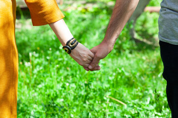 Fototapeta na wymiar couple hand in hand in garden