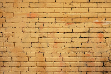 old tattered painted yellow brick wall. rough surface texture