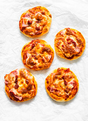Ham, tomato sauce, mozzarella pizza on a light background, top view. Delicious breakfast, snack, tapas