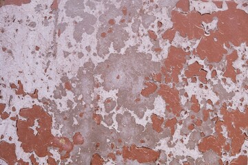 old shabby gray white concrete wall with peeling red paint. rough surface texture