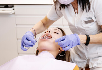 Obraz premium Crop dentist examining teeth of patient