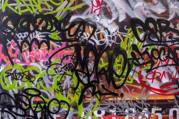 Tuinposter muur beschilderd met felle graffiti teksten. ruwe oppervlaktetextuur © Pavel