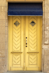 Beautiful front door in an old city. Elegant wooden door of yellow color.