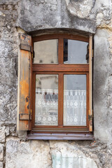 Vintage window with wooden shutters in an ancient stone house.