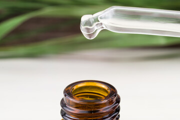 Essential oil with a drop falling from the pipette, aromatherapy, cosmetic serum
