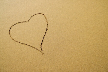 One simple heart outline on sand.
