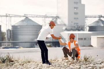 Engineers near the factory. Mtn in a helmet. Inspector looks at the building.