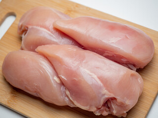 Fresh chicken fillet on a wooden board