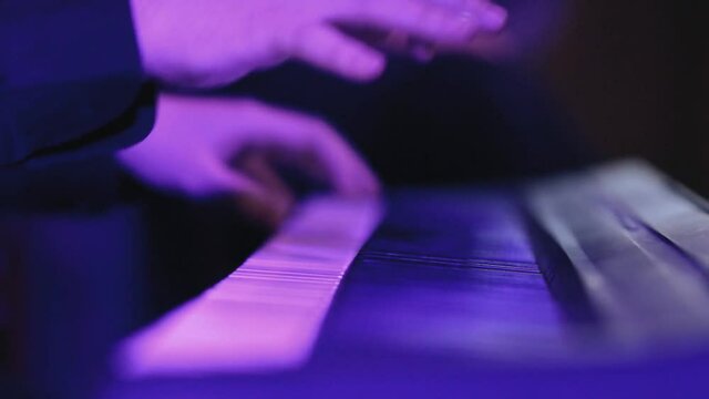 The hands of a musician closeup of the melody on the synthesizer.