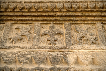 Lyllies carved in golden sandstone relief.