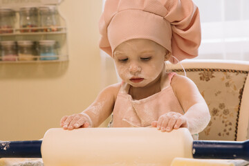 Little girl cooks at home in the kitchen