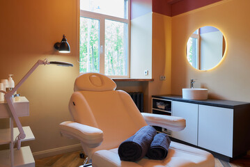 Interior of the cosmetology office with a full-electric beauty bed in a salon.
