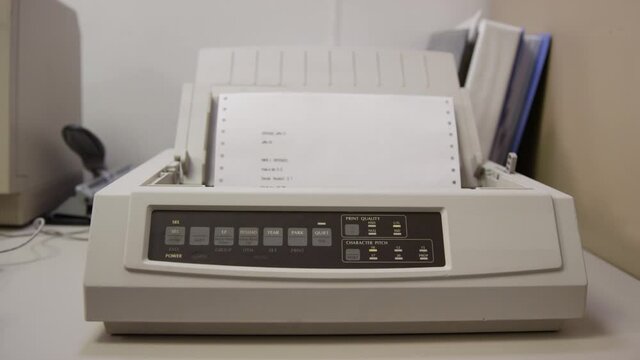 Old 9-pin dot matrix printer prints on perforated paper
