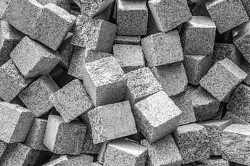 Gray stone paving stones as background. A pile of stone cubes as an abstract background.