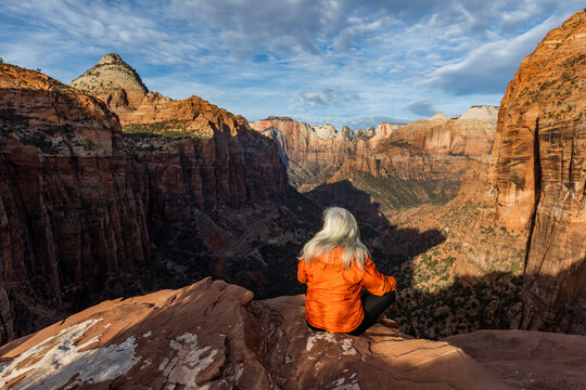 Woman sitting on cliff at Zion National Park in Utah, USA