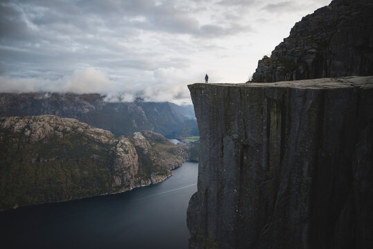 Person standing on Preikestolen cliff in Rogaland, Norway