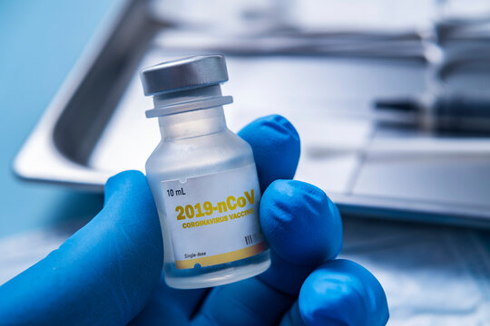 Close-up&dagger;of gloved hand holding vial of&dagger;Coronavirus&dagger;vaccine