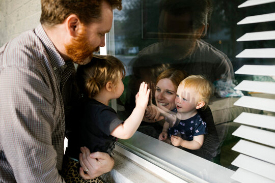 Family With Daughters (2-3) Visiting Through Window