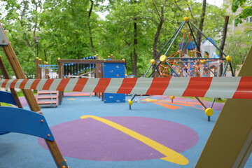 The children's playground in the yard of the house is closed and wrapped in a signal tape due to coronavirus. Prevention of coronavirus COVID-19.