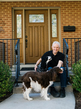 English springer spaniels and owner in front of house