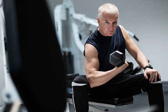 Man exercising with dumbbells on weight bench