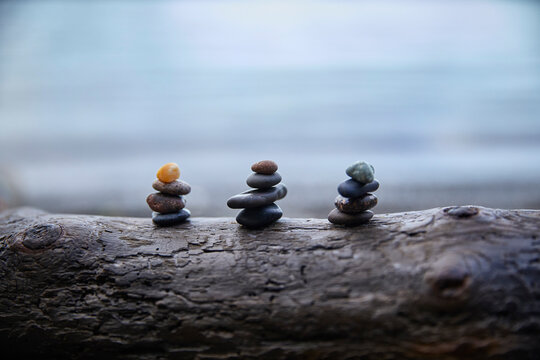 USA, Washington, San Juan County, Orcas Island, Stacks of pebbles on log
