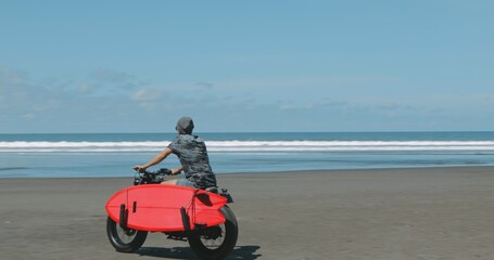 Obraz premium Motorcyclist driving his motorbike on the beach