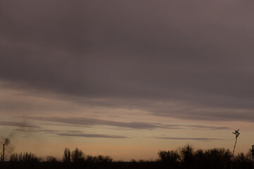 The sky covered by rain heavy gray clouds at sunset