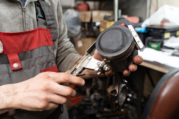 Car worker repair a pistons in autoservice. Piston defective checking.