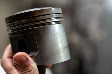 Car worker repair a pistons in autoservice. Piston defective checking.
