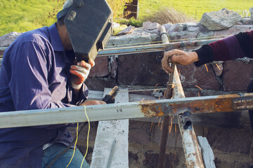 the man welds a roof