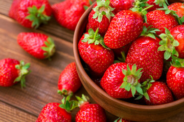 Fresh strawberries in a bowl on wooden table. Strawberry in a Bowl. Top view