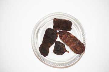 Acacia concinna or Shikakai pods used as herbal powder in India Asia. Hair fruit shampoo replacement for centuries. Ancient traditional ayurvedic dried herb in transparent bowl with white background