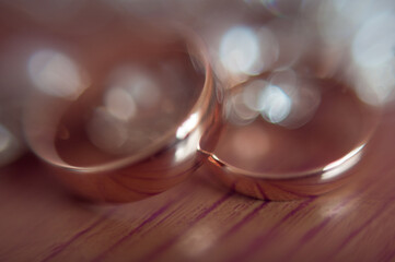 wedding rings on wooden background with bokeh closeup