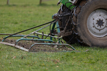 Traktor betreibt Weidepflege mit Weiseschleppe