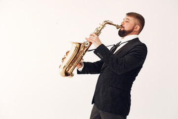 Man in a studio. Guy in a black suit. Musician with saxophone.