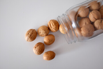 Walnuts spilled from a can on a white table