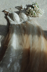 A wedding dress and a bouquet of flowers for the bride lying on the floor