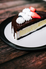 cheesecake cake cut with chocolate on a black plate