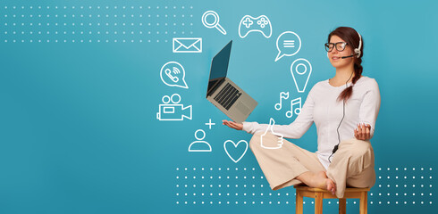 Woman is siting in lotus position on a chair with a laptop.