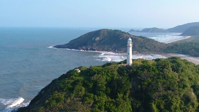 Beatiful lighthouse on the top of a montain of an island with beaches and blue sky 