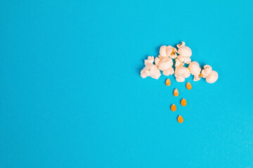 Rainy cloud made out of popcorn on a blue background