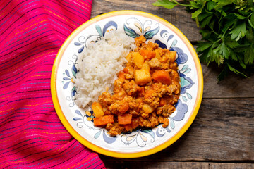 Mexican picadillo with rice on wooden background