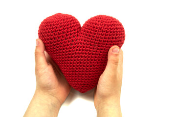 Red heart in child hands isolated on white background. Red plush heart in child hands on white.