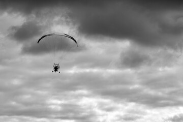 Silhouette of a man on a moto paraglider, motoparaplan, flying in the sky.